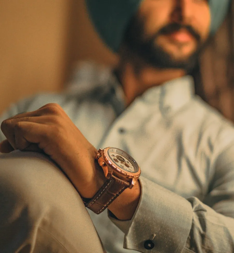 brown strap watch worn on the wrist with a light shirt